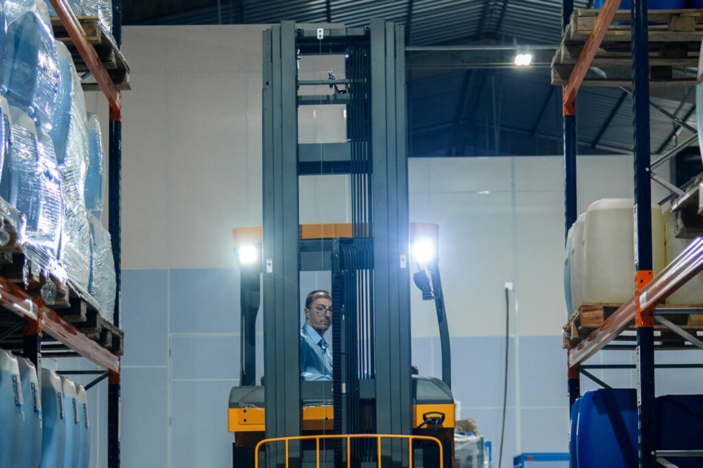 Empilhadeira retrátil RTX2074 MAX com os faróis acesos no corredor